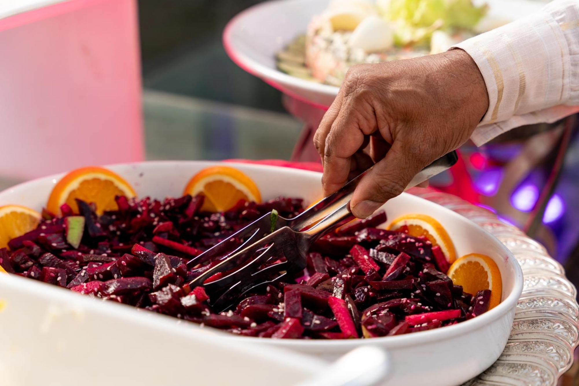 Sheraton Dammam Hotel & Convention Centre Buitenkant foto A hand using a buffet server to serve food