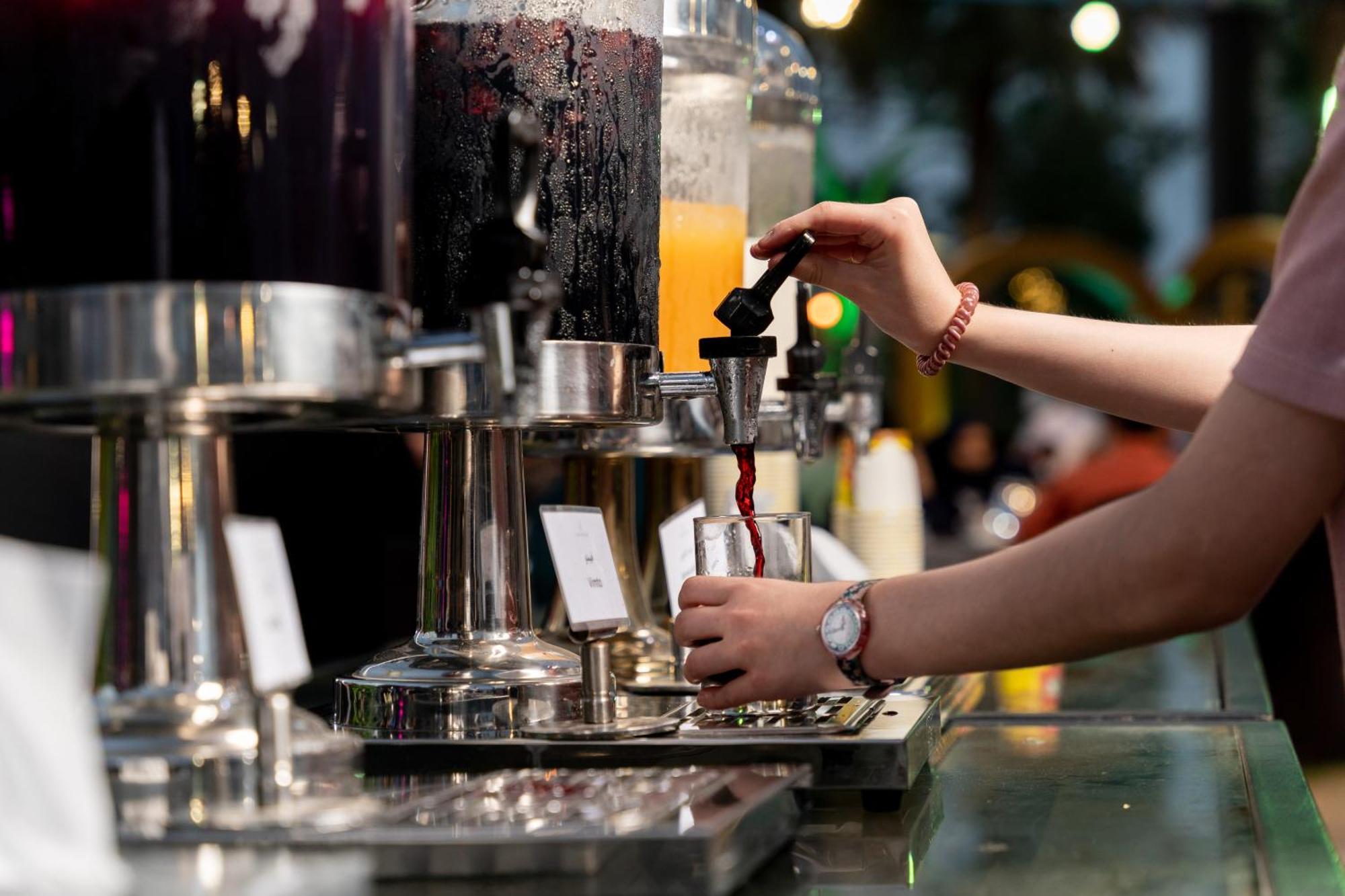 Sheraton Dammam Hotel & Convention Centre Buitenkant foto A bartender using a tap to serve a drink